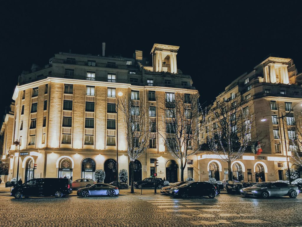 Night view of the illuminated Four Seasons Hotel George V, Paris with nearby traffic.