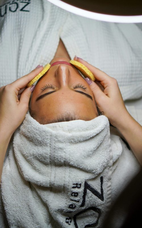 Relaxing spa treatment with facial and sponge massage in a serene environment.