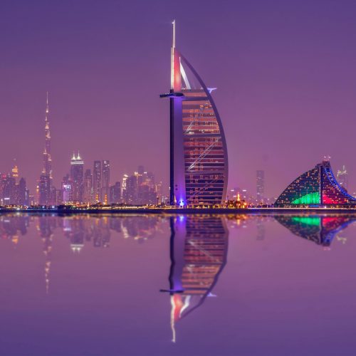 Captivating night scene showcasing Burj Al Arab and Dubai skyline reflections.